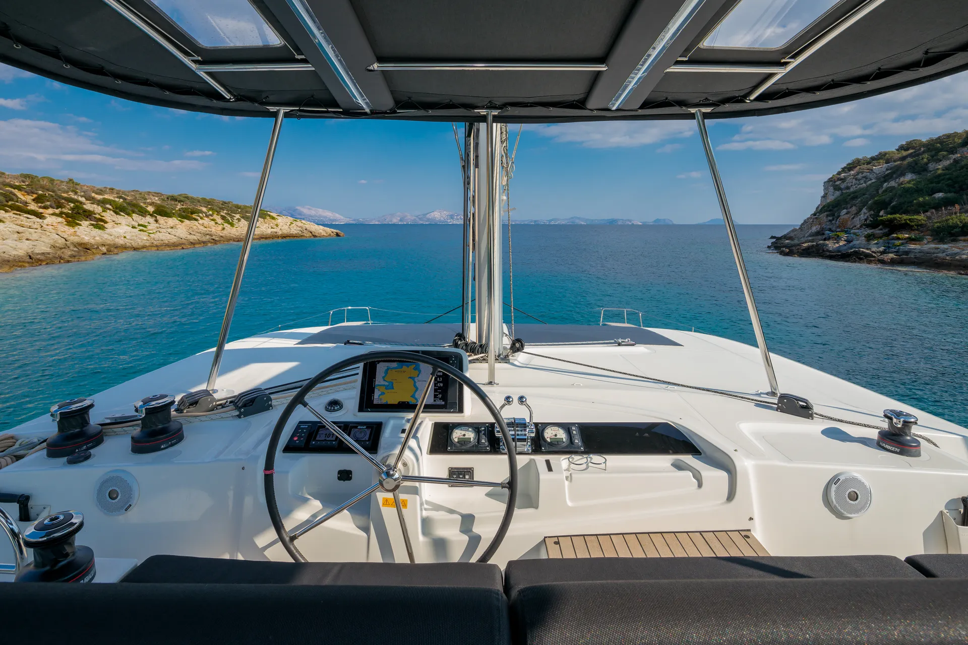 White Rock 36 speedboat with captain at helm cruising calm blue waters near Paros coastline with hills in background.