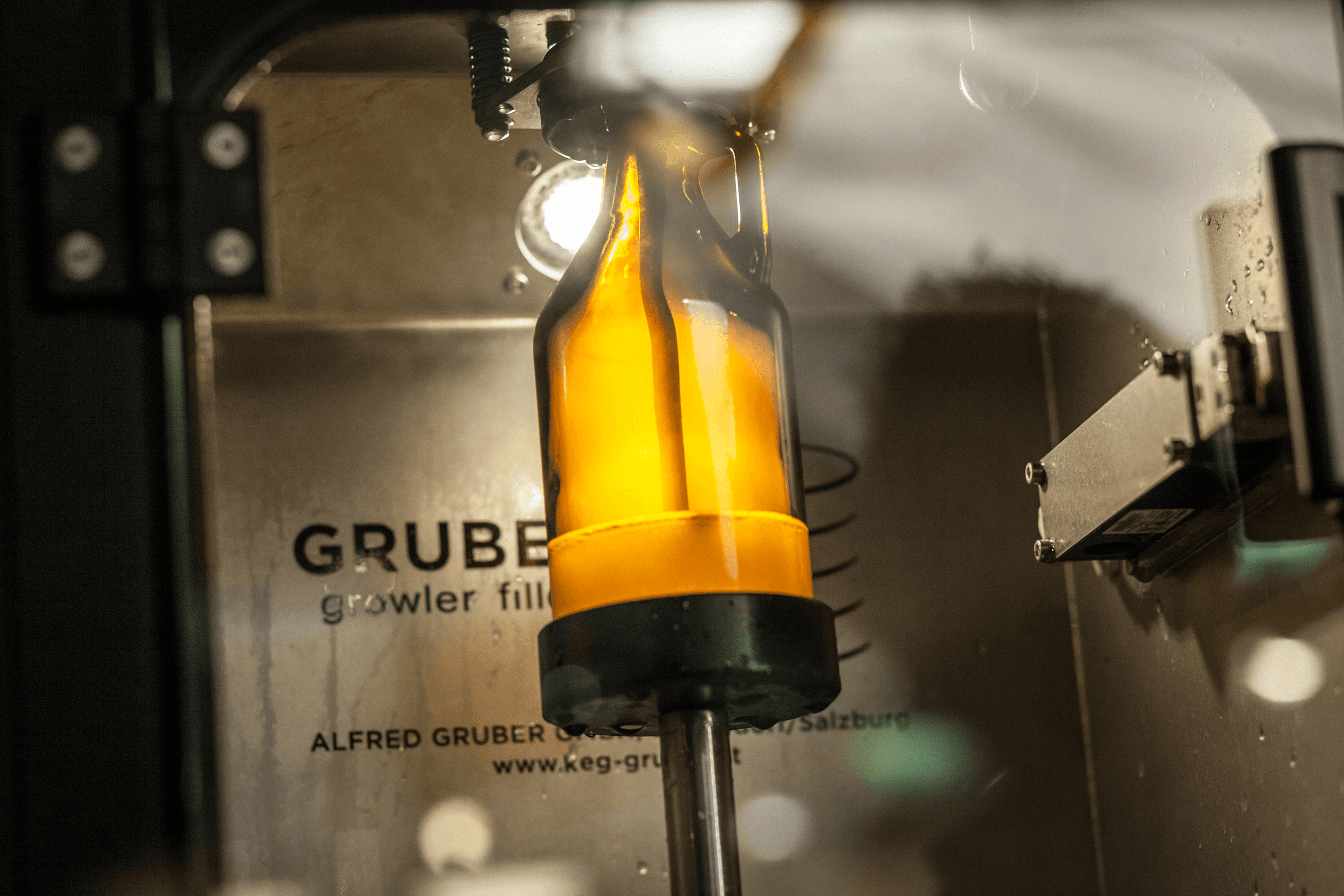Filled glass bottle in a growler filler machine.
