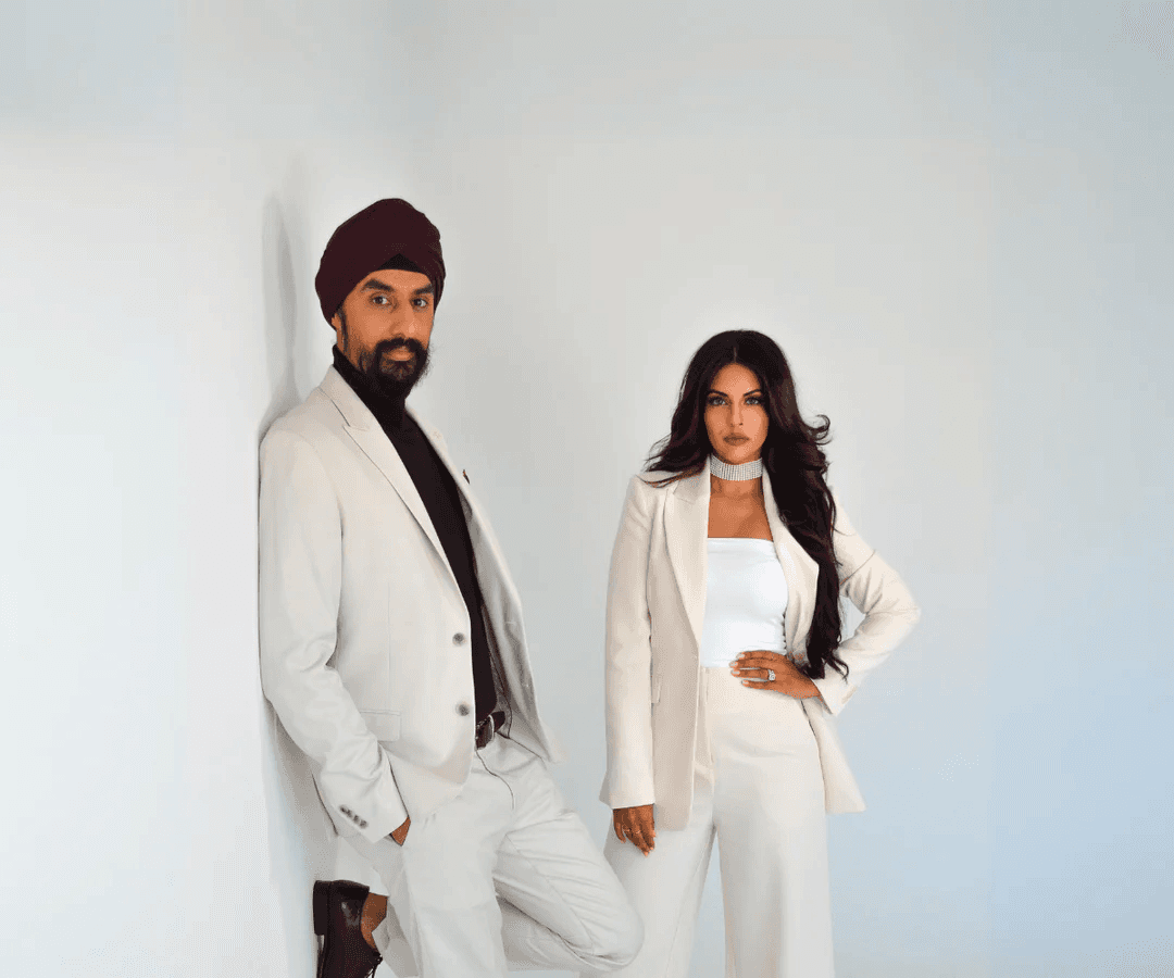 man in white suit standing beside woman in white dress on rock during daytime