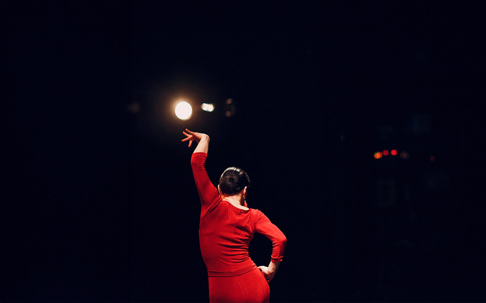 Flamenco dancer in red dress performing on stage at Las Setas, Seville.