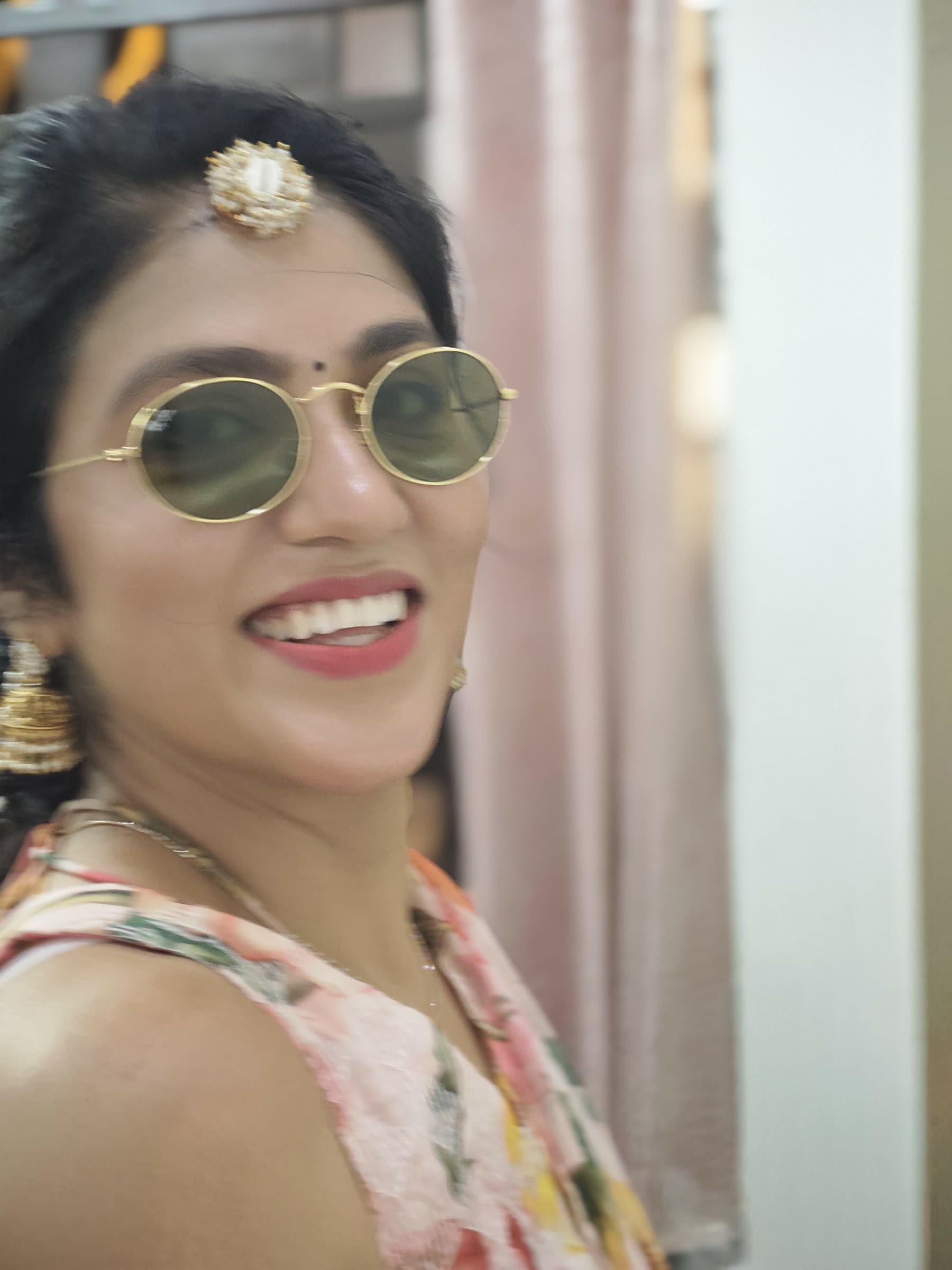 Sarika smiling in festive attire and sunglasses