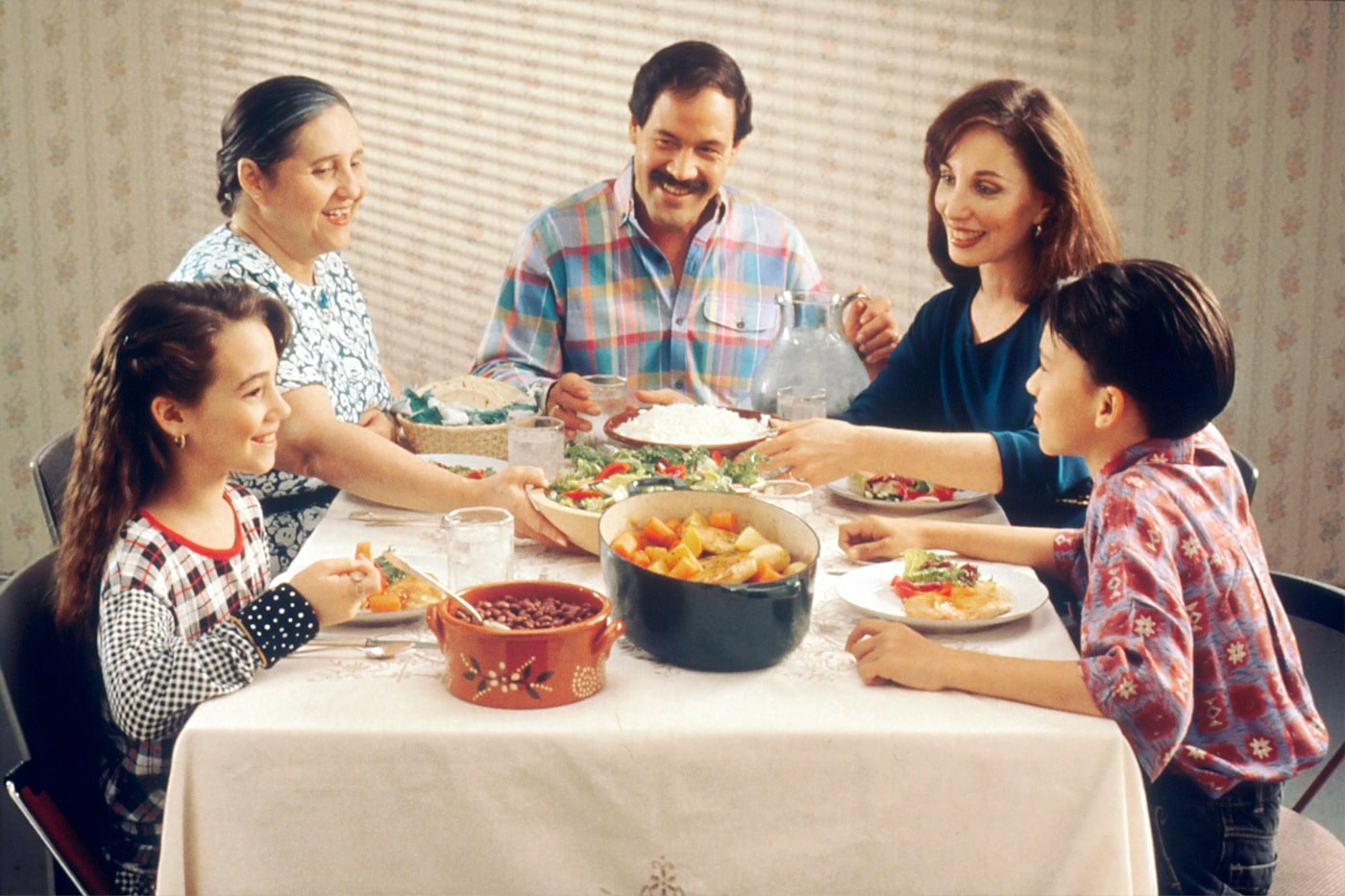 A family gathered around a table sharing a meal together, showing that eating with a food allergy can still be social and enjoyable