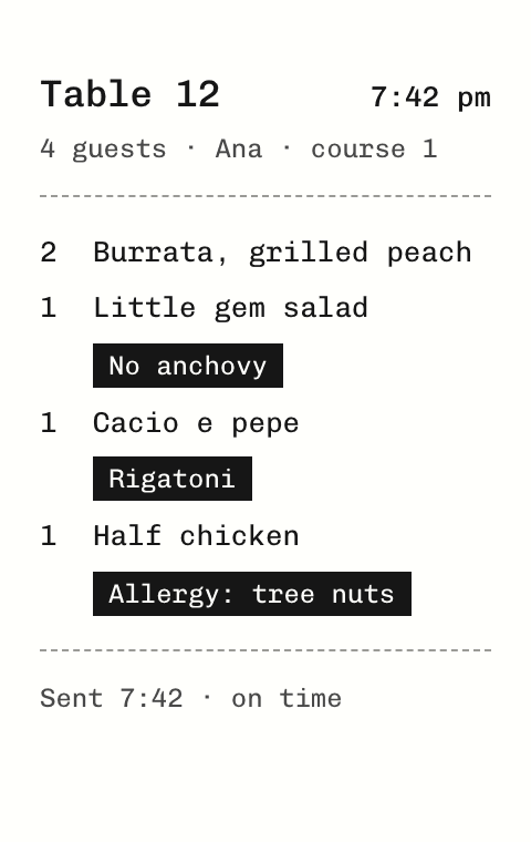 Kitchen ticket for table 12 with an allergy printed in reverse