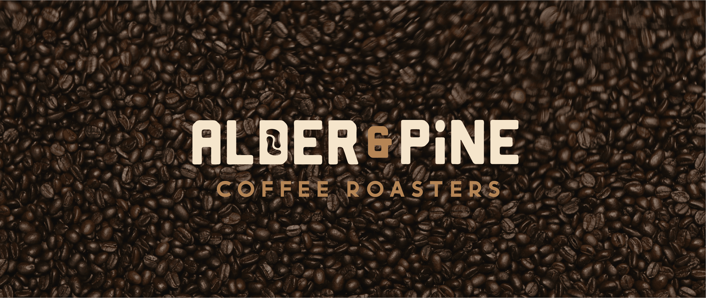 Graphic design mockup of a wordmark for Alder & Pine Coffee Roasters — modern, clean wordmark logo of a footprint and a coffee bean with a bold decorative sans serif typography over a photo of coffee beans, designed by Will Lefkovich.