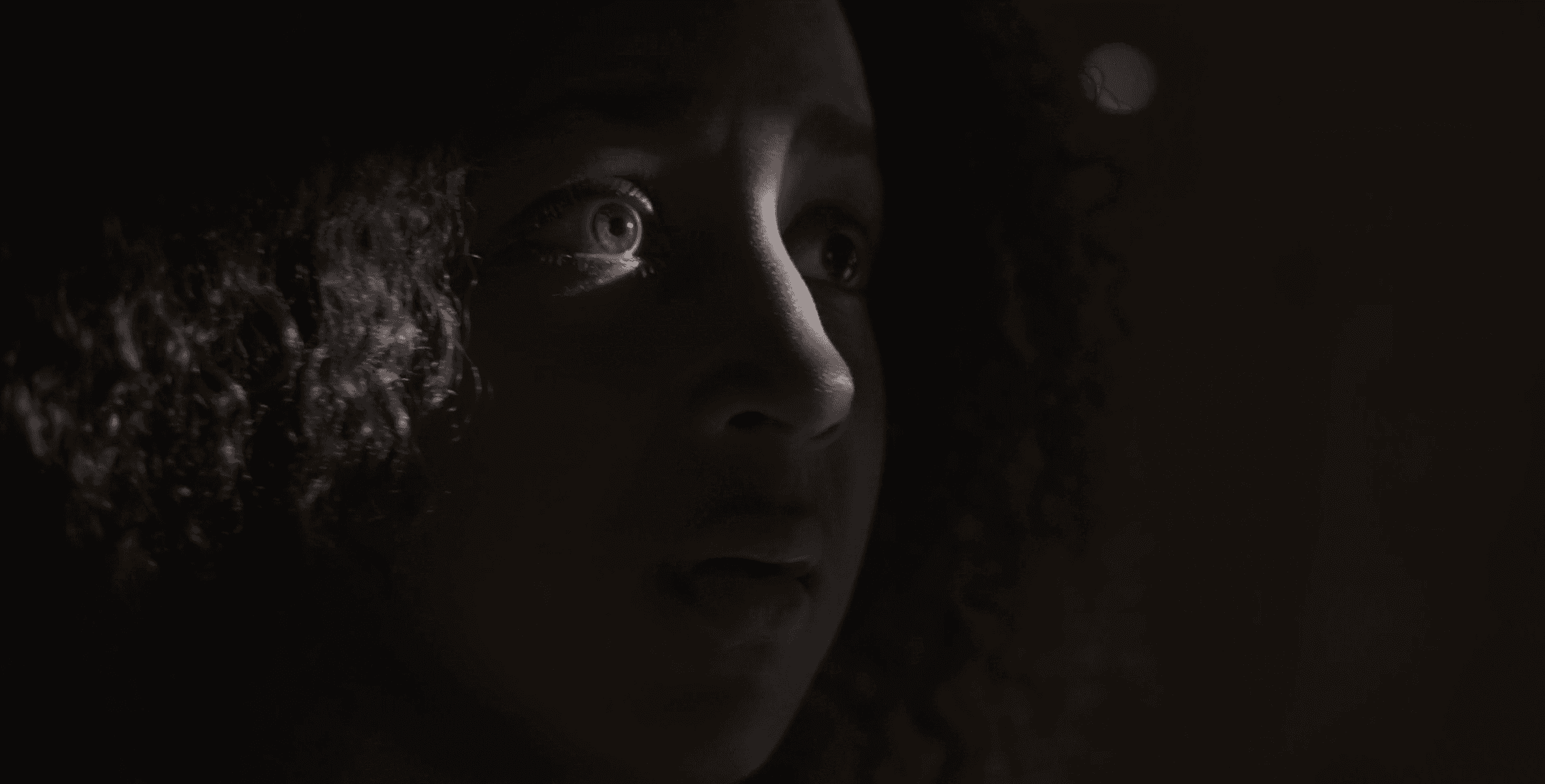 A Black girl (Mila Davis-Kent as Sarafina) looking in horror.