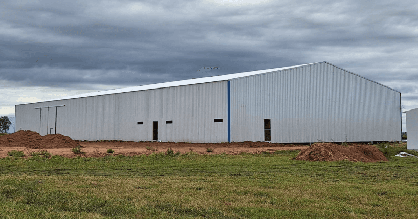 Galpón logístico metálico de 25x60 metros construido con estructura de acero y cerramiento de chapa blanca para depósito industrial en Argentina