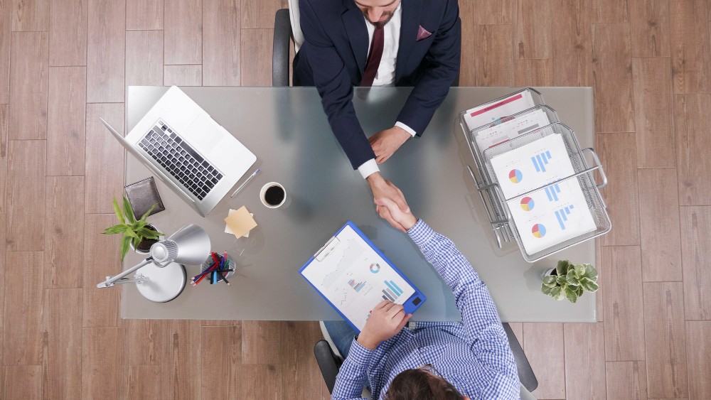 Un vendedor actuando como consultor en una reunión de negocios, escuchando activamente a su cliente