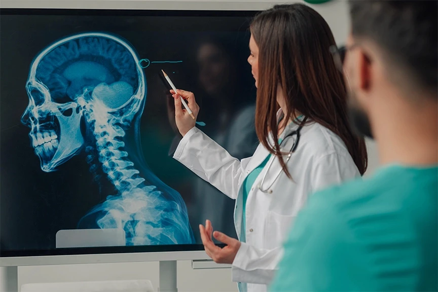 Physicians examining spine scan images to assess injury and treatment needs