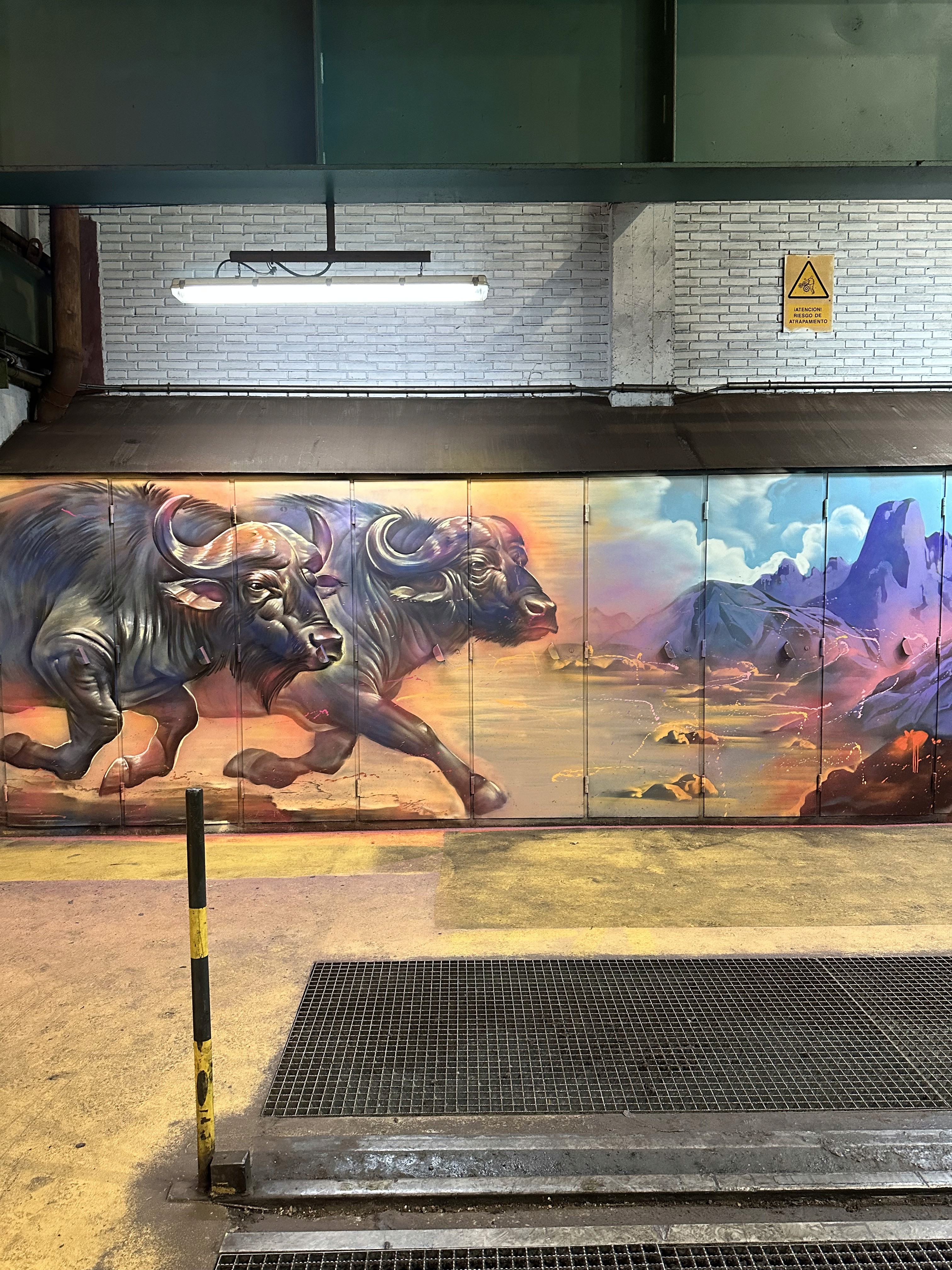Ejecución de un mural sobre las puertas metálicas de la nave de ArcelorMittal en Avilés