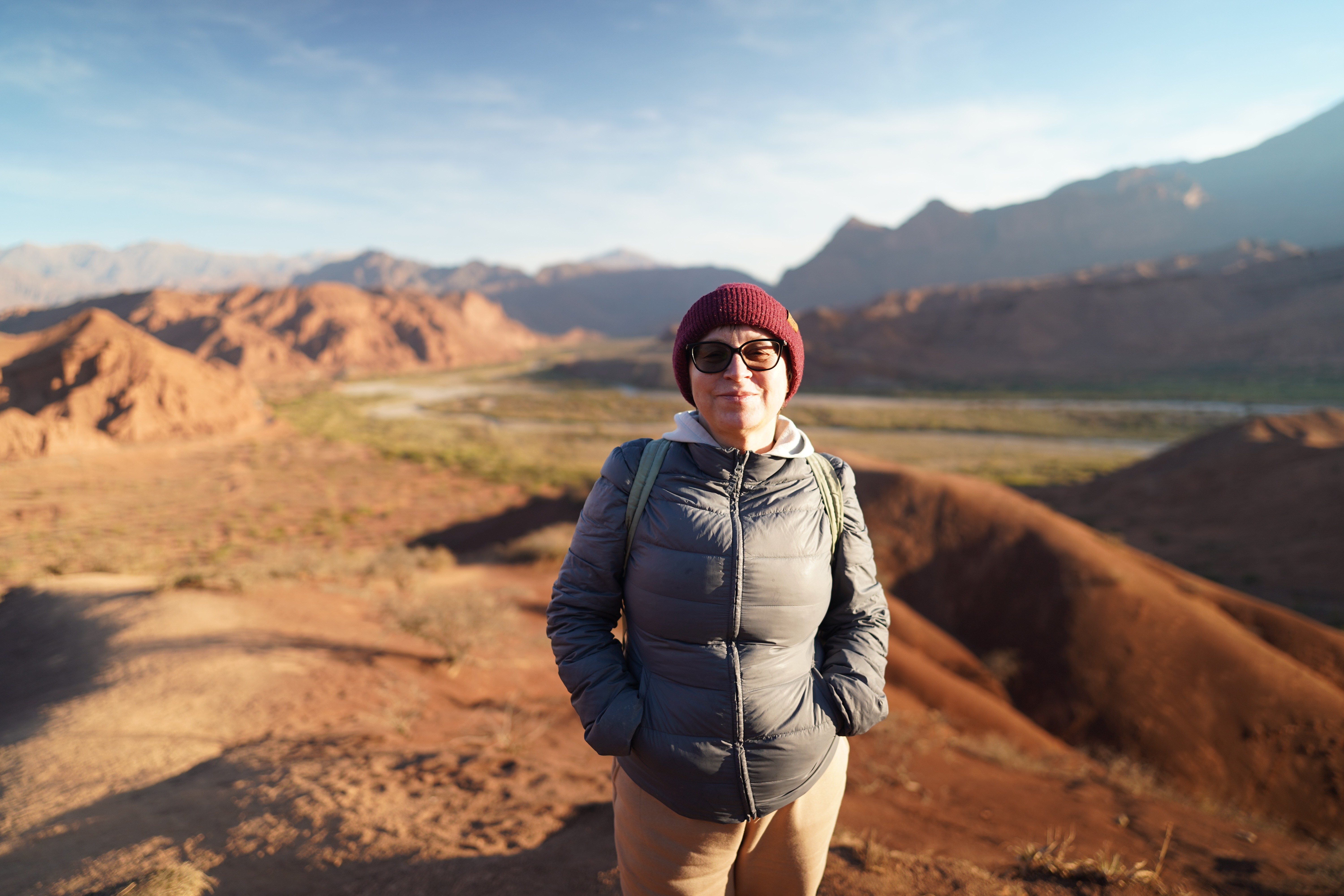 Svetlana Gabitova de pie en un paisaje de montañas rojas en Argentina.