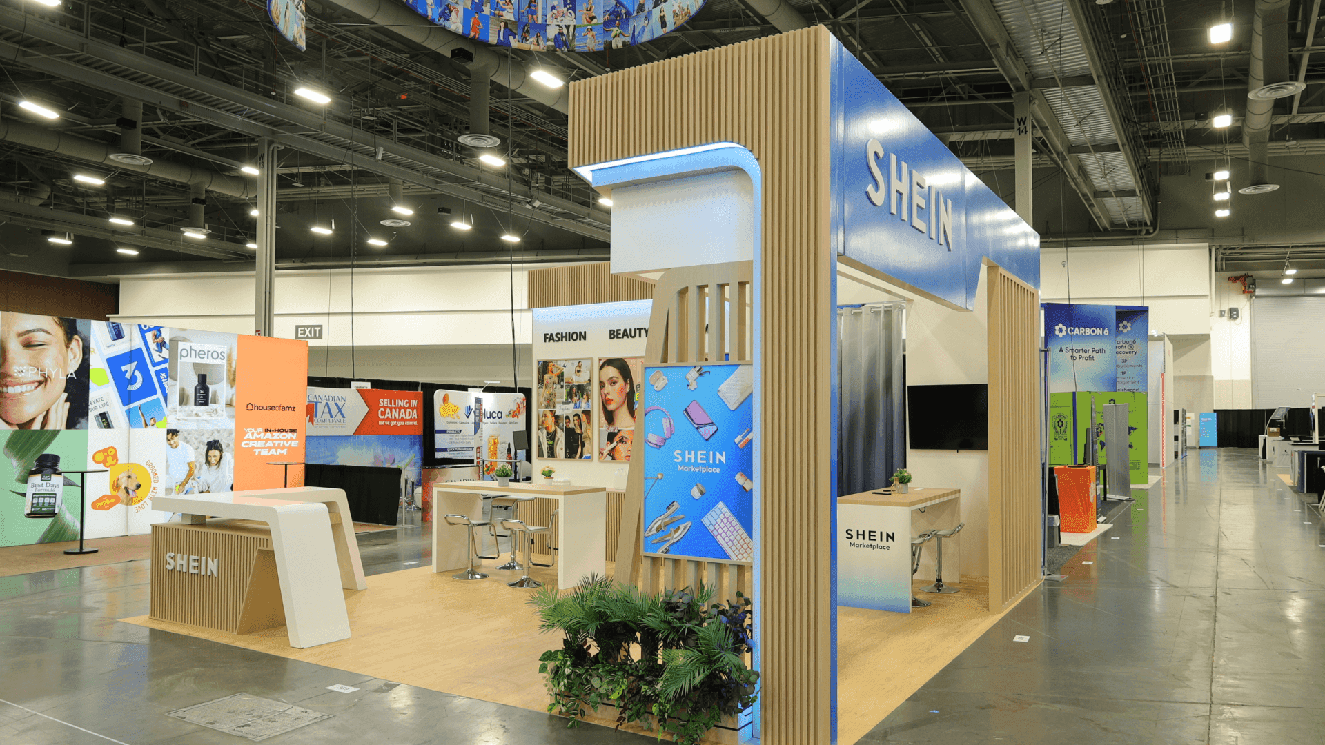 SHEIN Prosper Show 2025 20x20 booth with fashion beauty home category wall, lifestyle image panels, consultation table, and branded retail display area