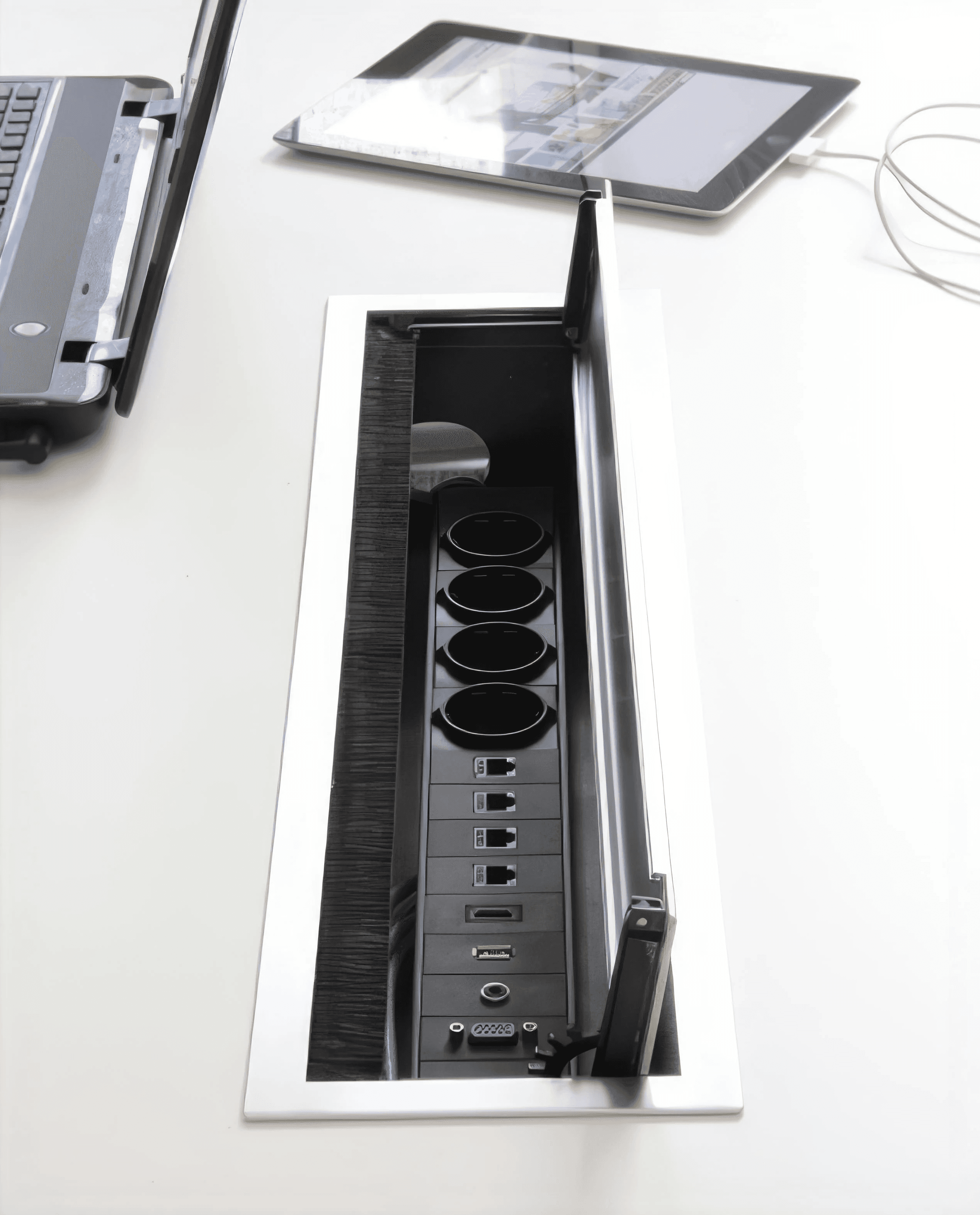 MW Interior - Aufgeklappte Tischanschlussbox mit Steckdosen, USB, HDMI, LAN und VGA-Anschlüssen in weißer Konferenztischplatte" Beschreibung: Versenkbare Tischanschlusseinheit mit Strom, LAN, USB, HDMI und VGA – sauber in die Tischoberfläche integriert und bei Bedarf aufklappbar für maximale Konnektivität am Arbeitsplatz.