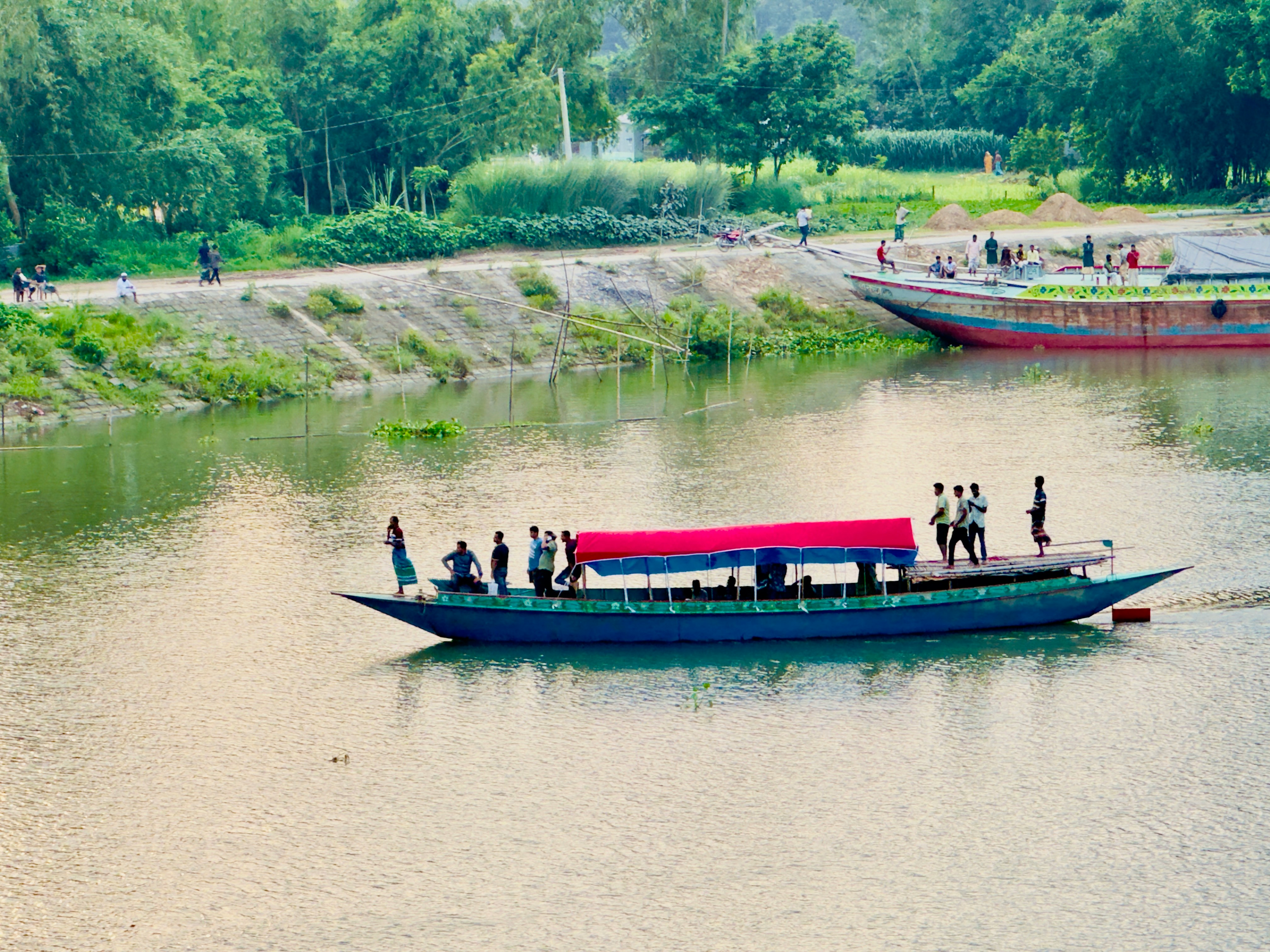 People on a boat sailing on a wide river.