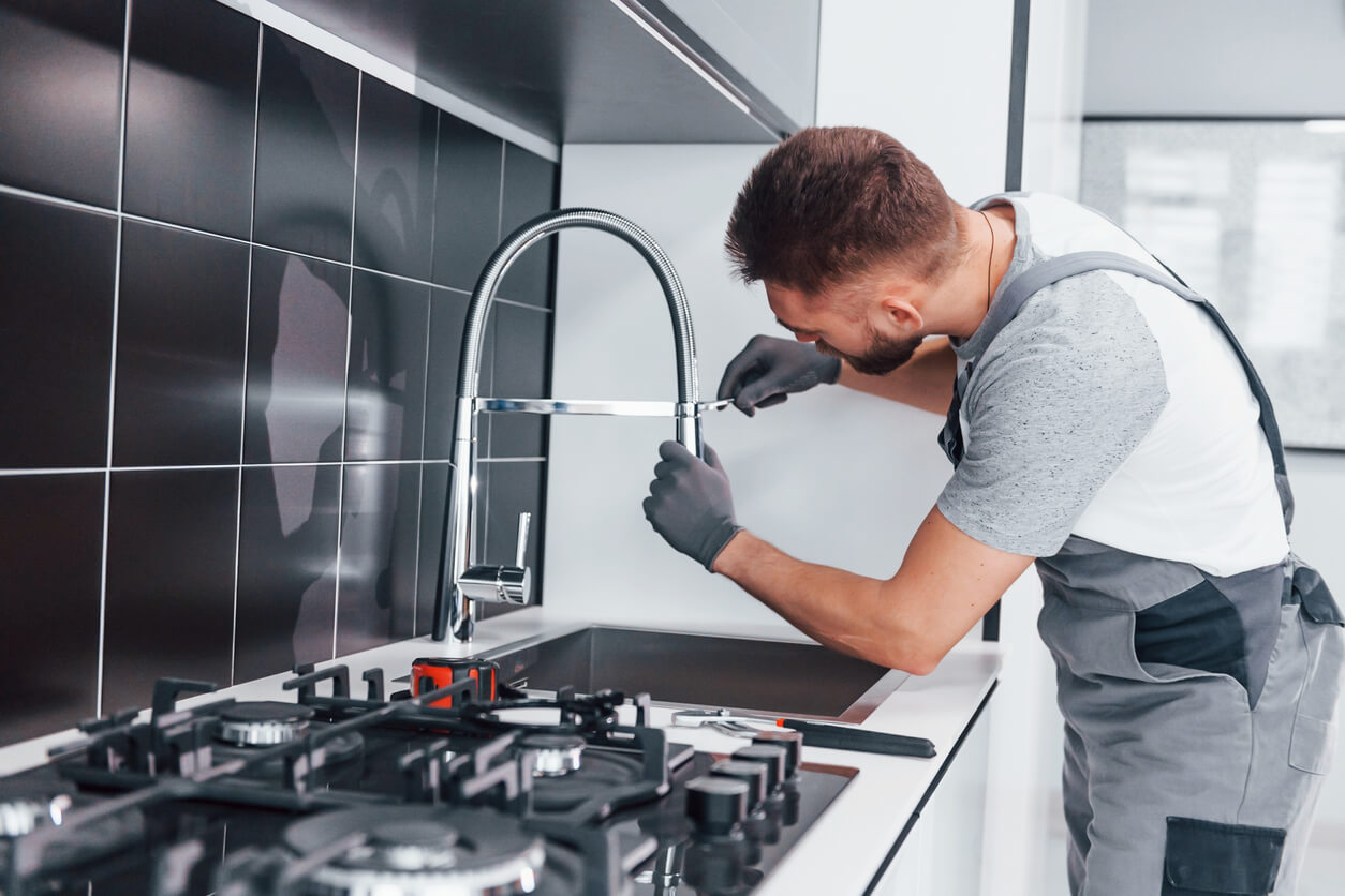 Plumber at work fixing a leaky tap