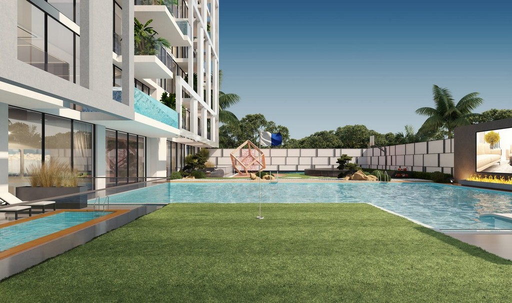 A swimming pool in front of the modern Vue Doree Crystal Bay apartment building, showcasing contemporary architecture.