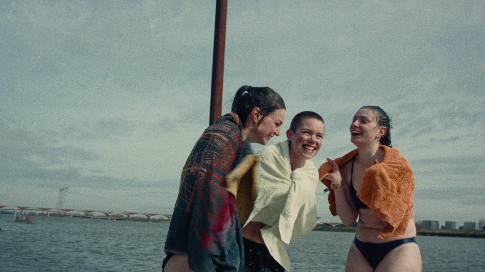 Drie blije personen met een handdoek om