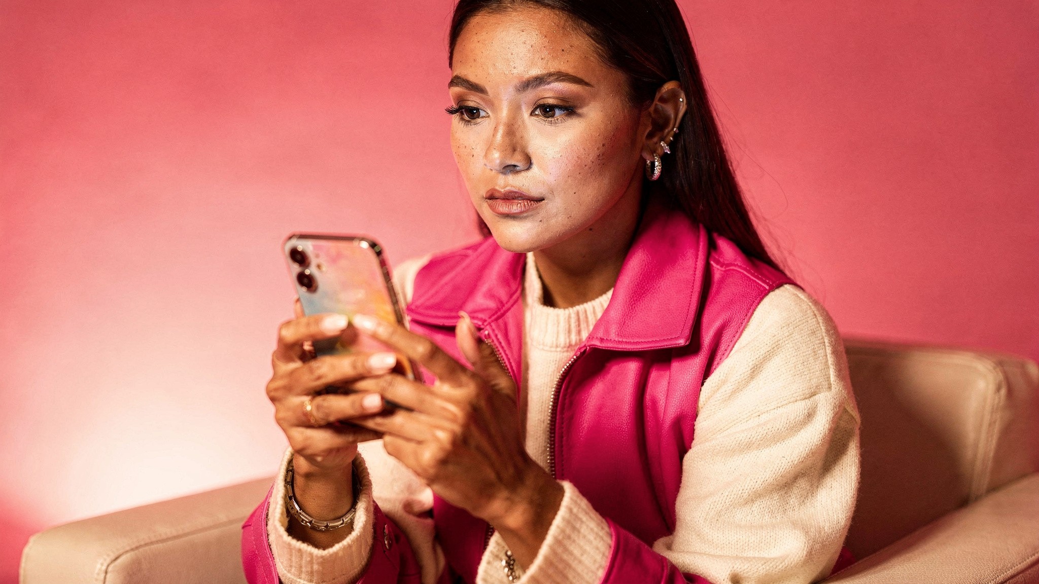 Lifestyle creator looking thoughtfully at her phone, considering whether Instagram hashtags still affect reach