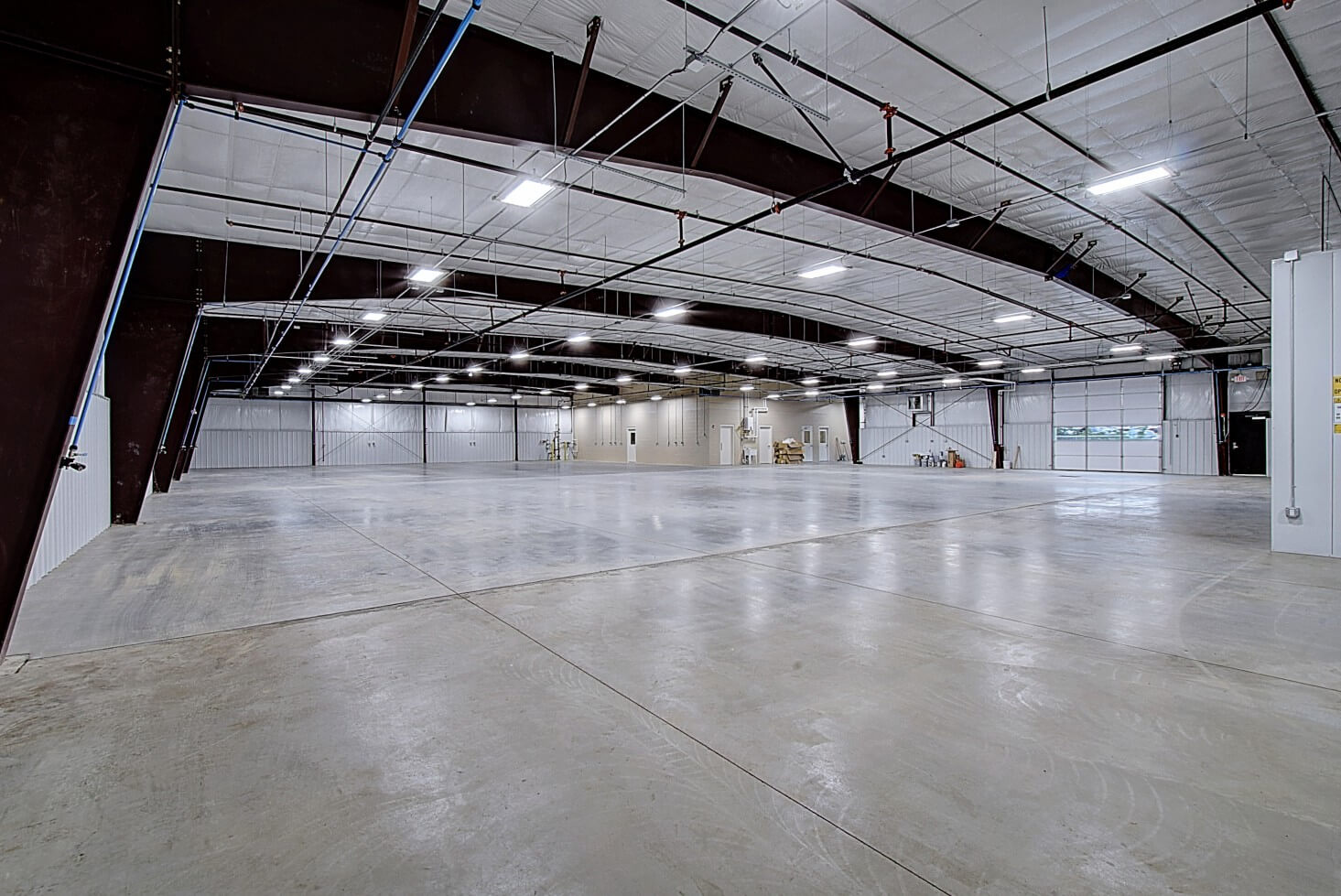Large interior space with overhead lighting and white walls and ceiling