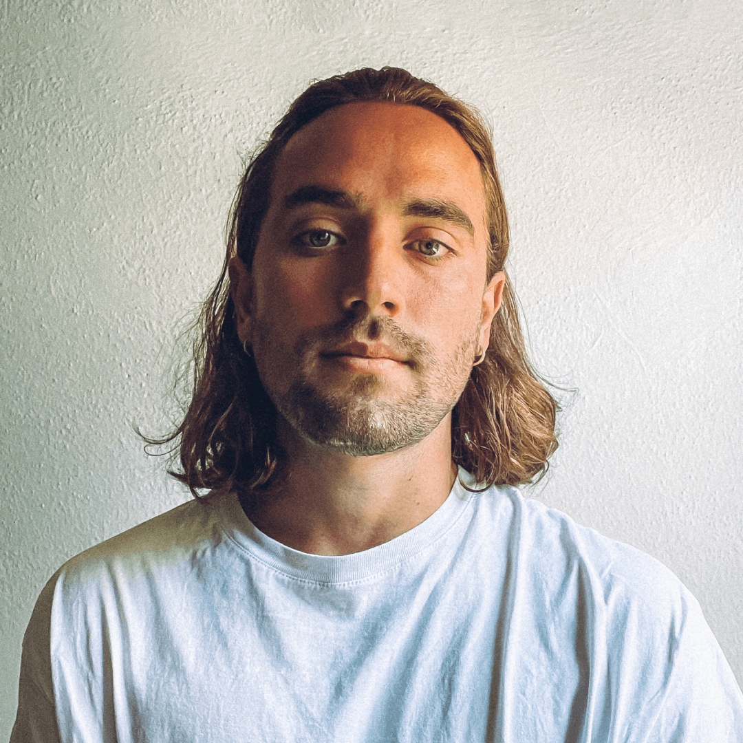 Profile portrait of a man in a white shirt against a light background