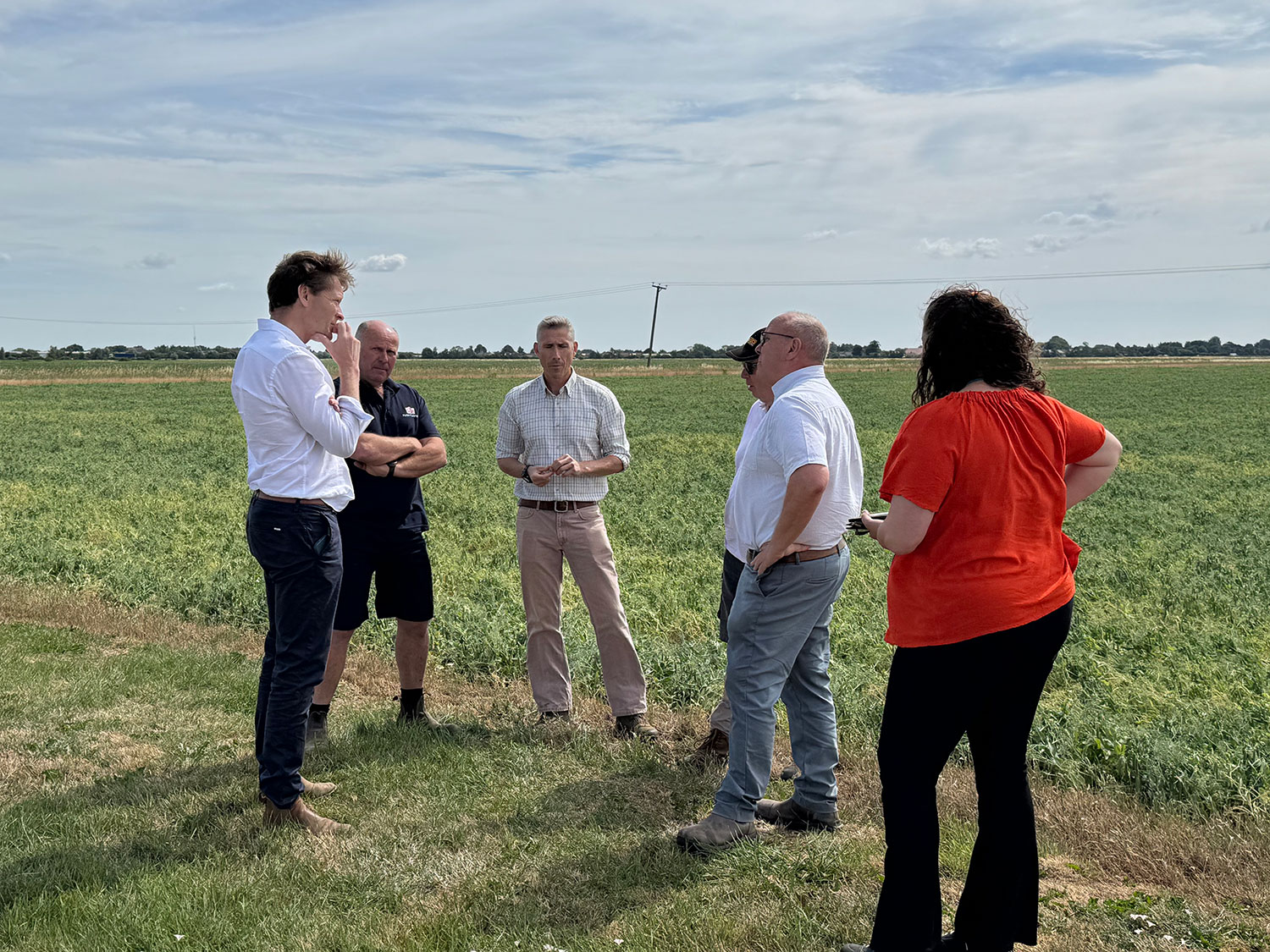 Richard Tice MP talks to farmers whilst standing in a field