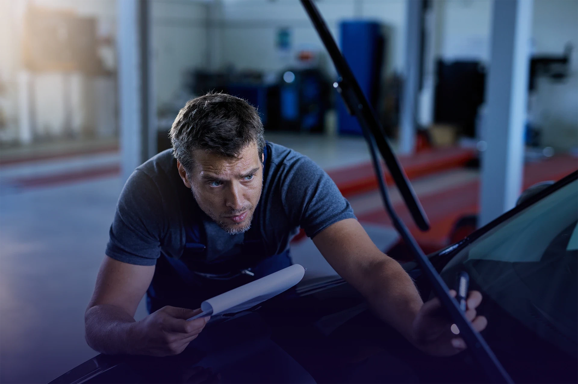 Professionnel de l’automobile réalisant une intervention mécanique lors d’un entretien véhicule