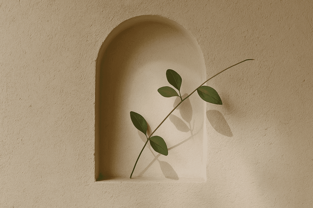 A person wearing headphones sits at a desk with a large curved monitor displaying graphic design software, surrounded by a laptop, smartphone, and potted plant, creating a modern workspace setup.