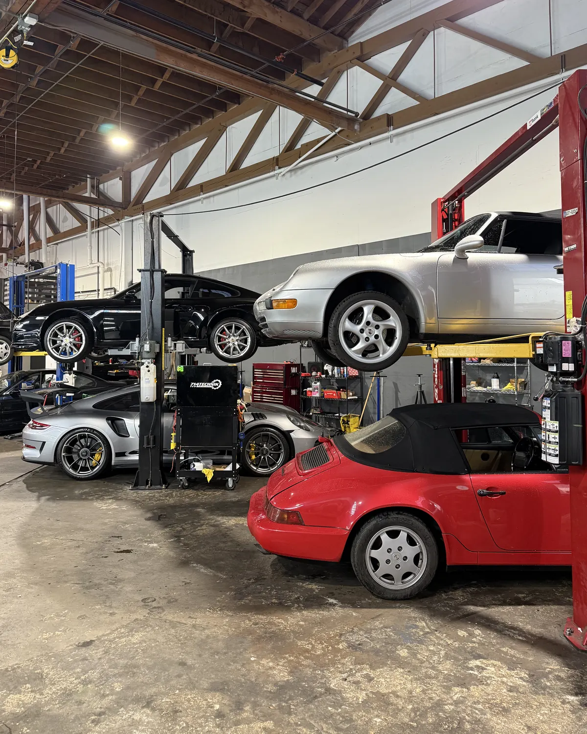 Porsche 911s on lifts in the 714 Technik service bay in Portland, Oregon