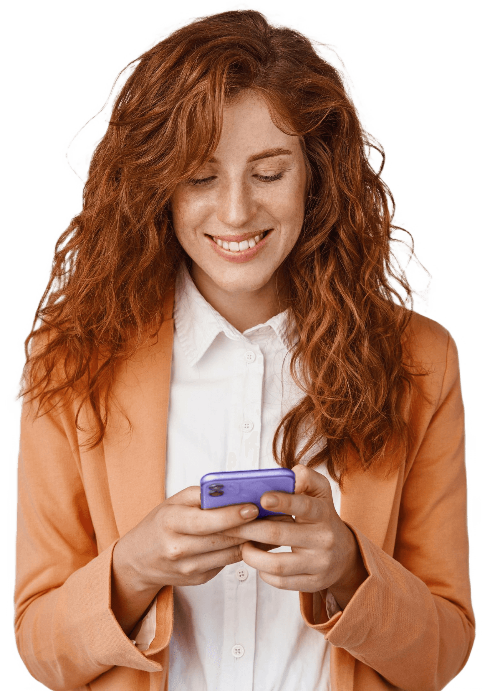 A smiling woman with red hair is looking down at her mobile phone.