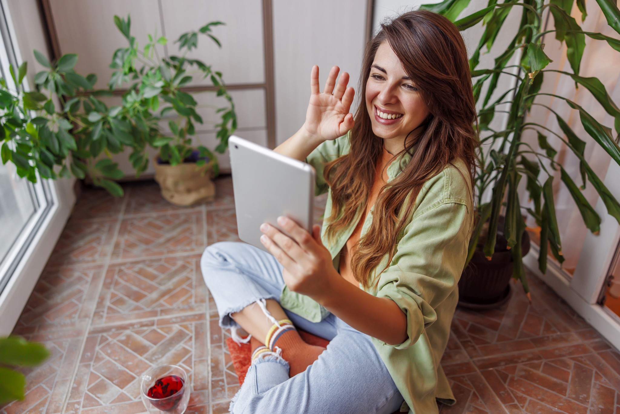 Smiling woman on a video call with a tablet in a bright room