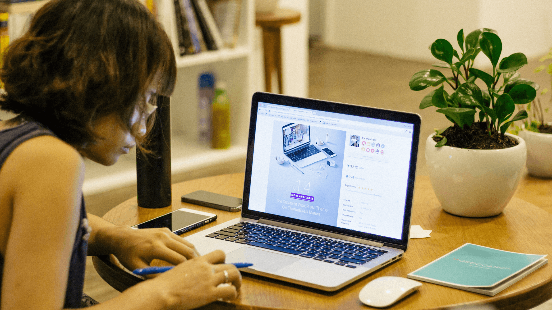 A woman working on a laptop, entering product information into a PIM