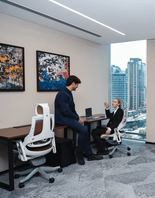 Seating area in serviced offices with beige chairs, moss wall decor, and wood paneling.
