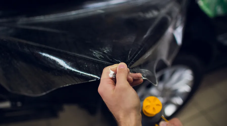Applying clear protective film to car panel