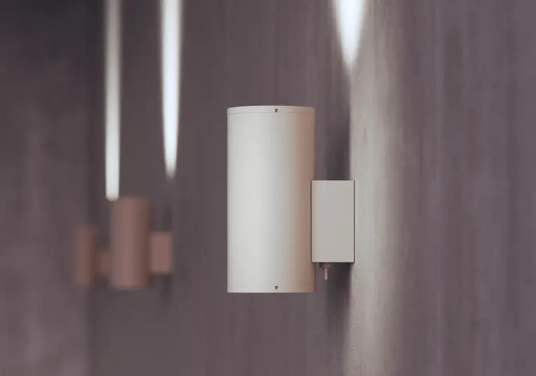 Lámpara de pared LED de Beneito Faure, diseño cilíndrico moderno, iluminación cálida en pared gris, estilo minimalista y contemporáneo para interiores