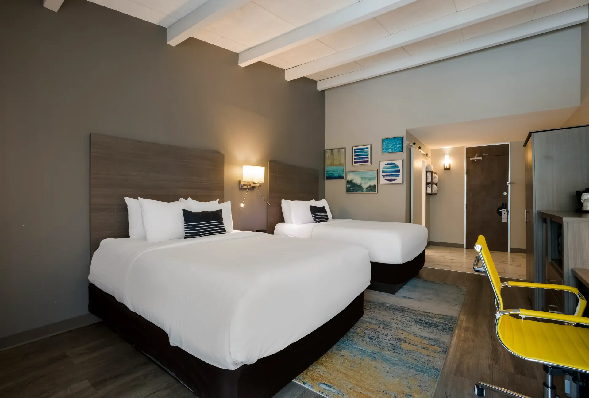 Hotel room with two beds and a yellow chair