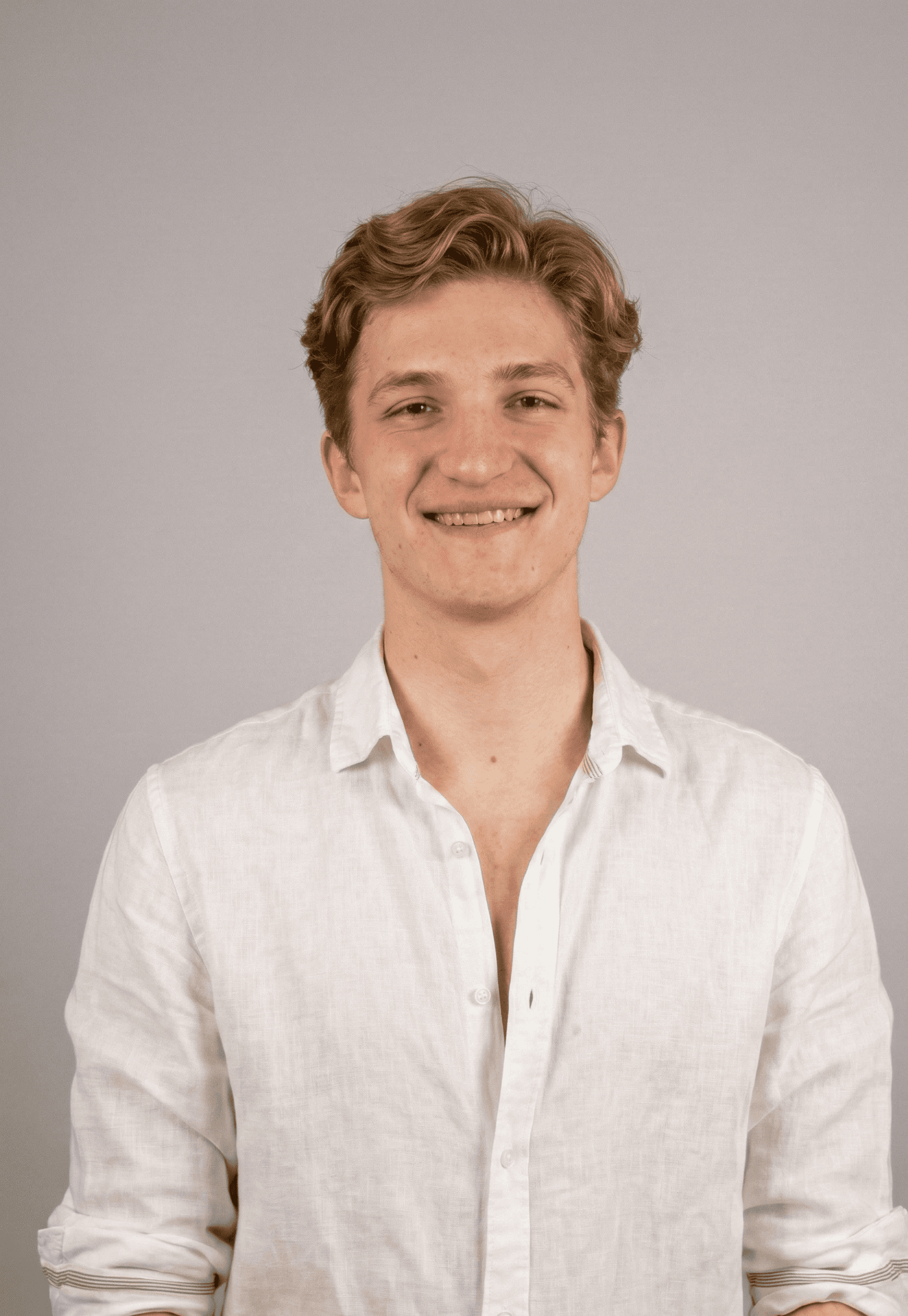 Portrait of a laughing person with curly hair wearing a white shirt