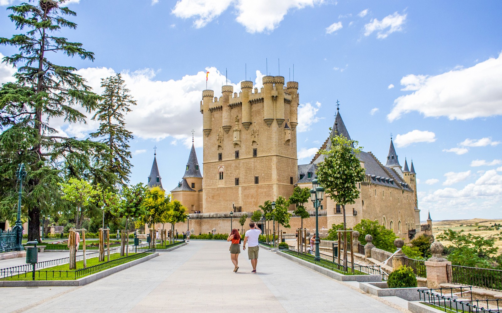 Toeristen lopen richting het Alcázar van Segovia, Spanje, met zijn kenmerkende torens.