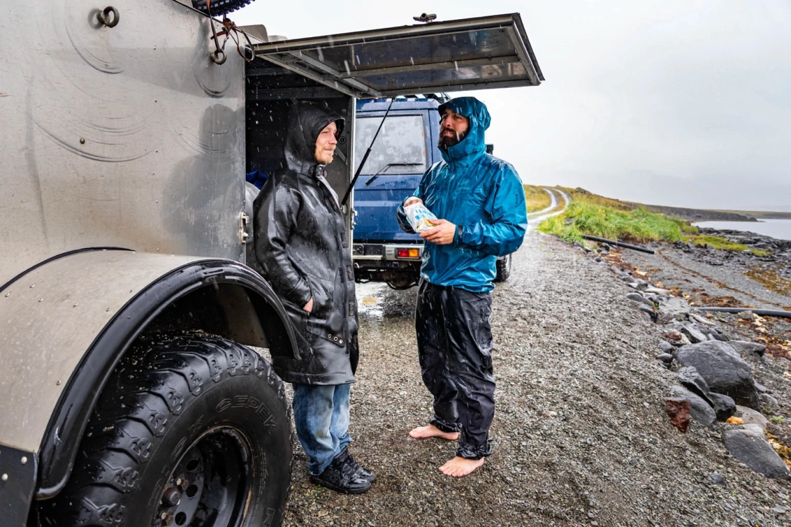 Two men use Icebike trailer as a shelter for weather