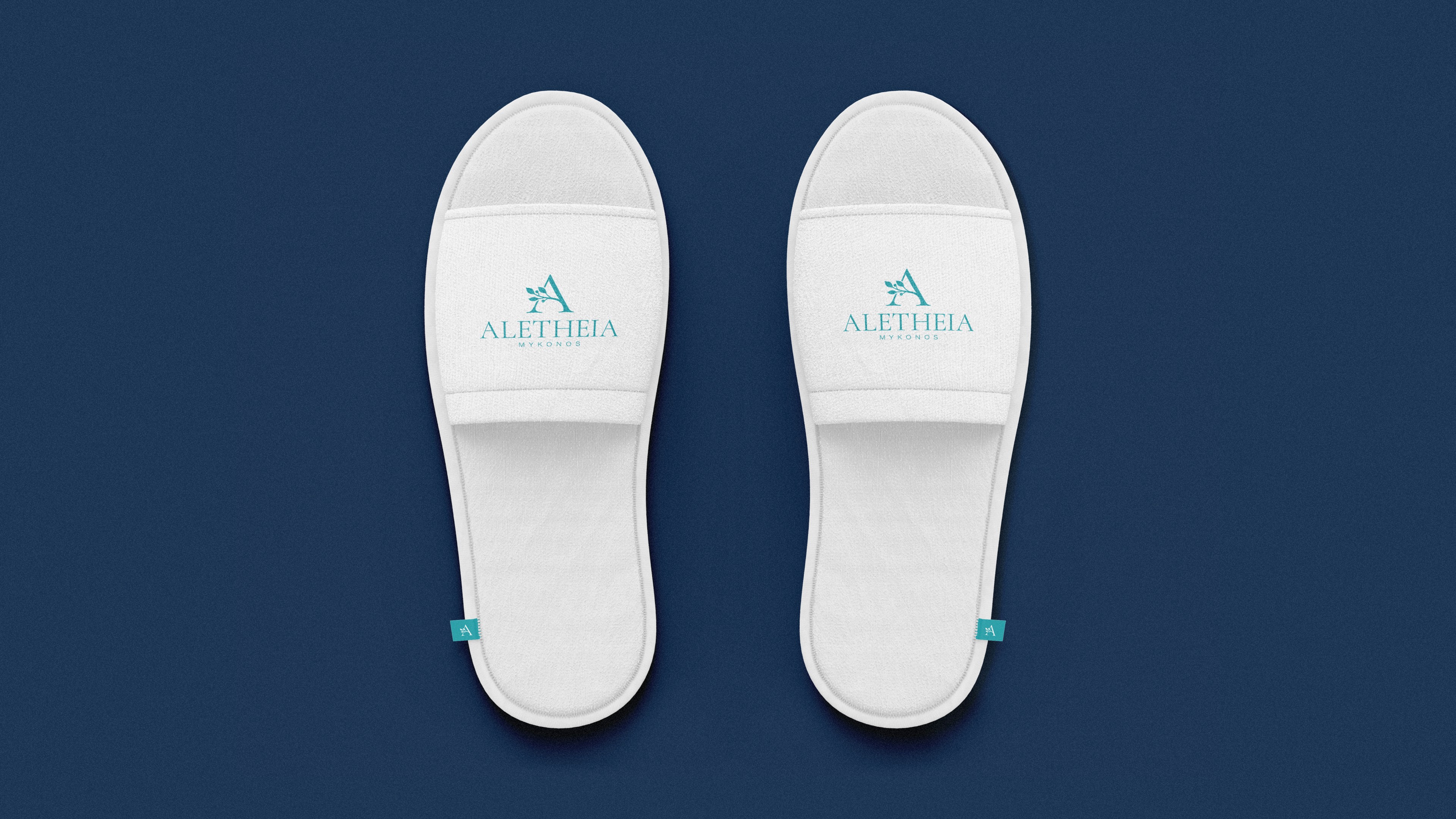 White hotel slippers with a blue logo for a Greek hotel