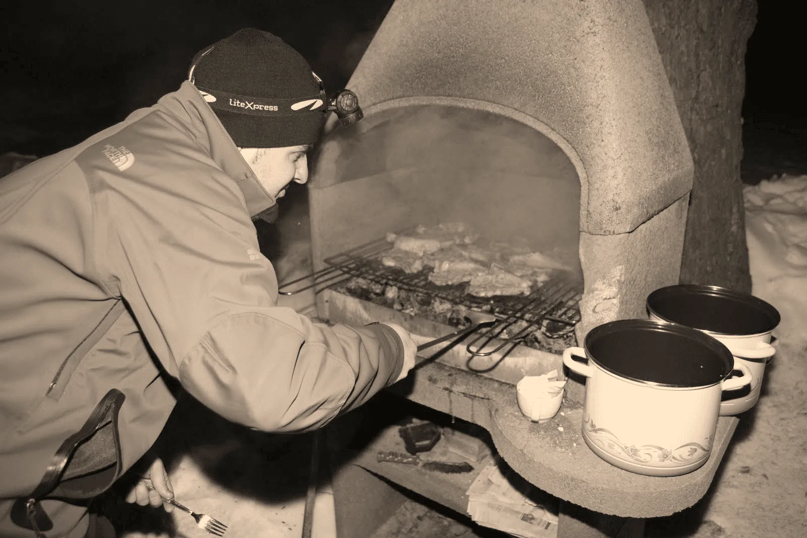 Mann am Holzkohlegrill für Grill-Spezialitäten bei Mangal Mezze & Grill Saarbrücken.