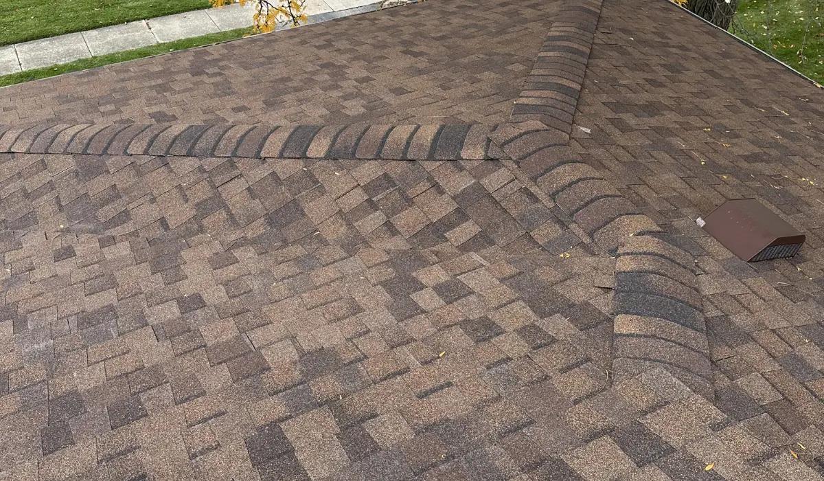 Asphalt roof with visible shingle wear, discoloration, and aging patterns, showing early signs that may require roof replacement in spring.
