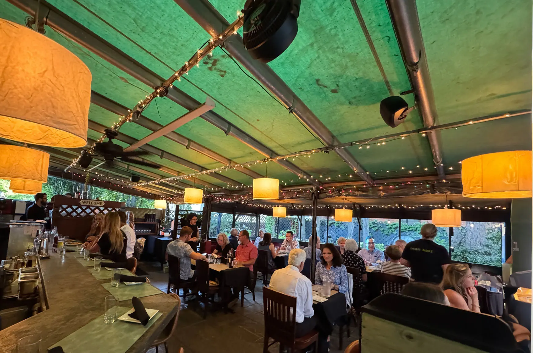 Covered terrace dining room with string lights at Basi Italia