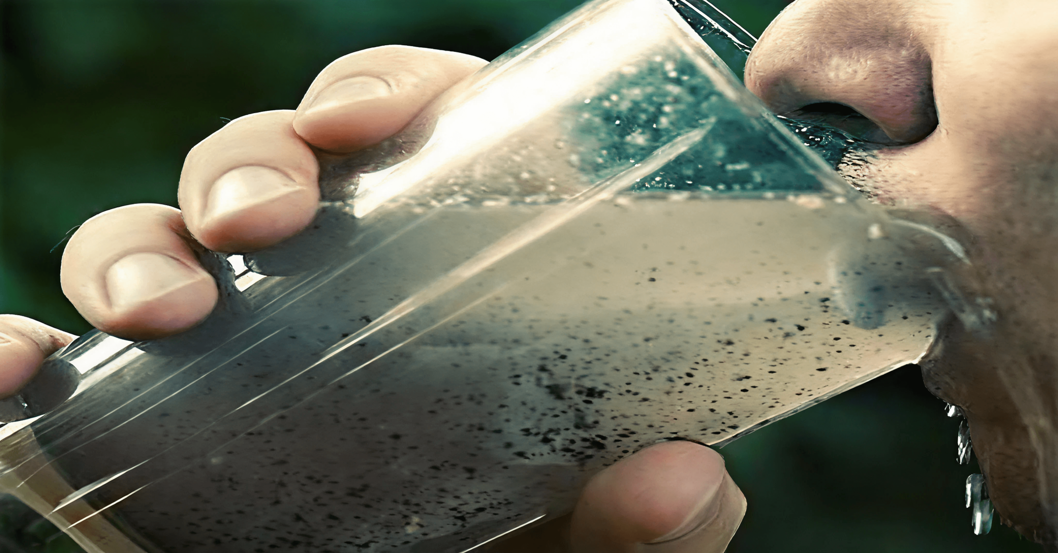 Person drinking contaminated water from a glass, highlighting the risks of waterborne diseases.