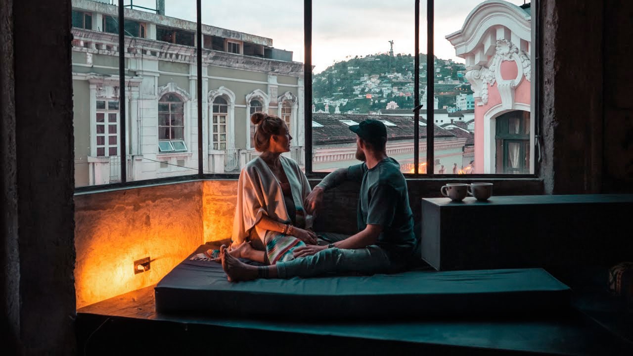 Bre and Flo sat together in a cozy room with large windows overlooking a daytime cityscape.