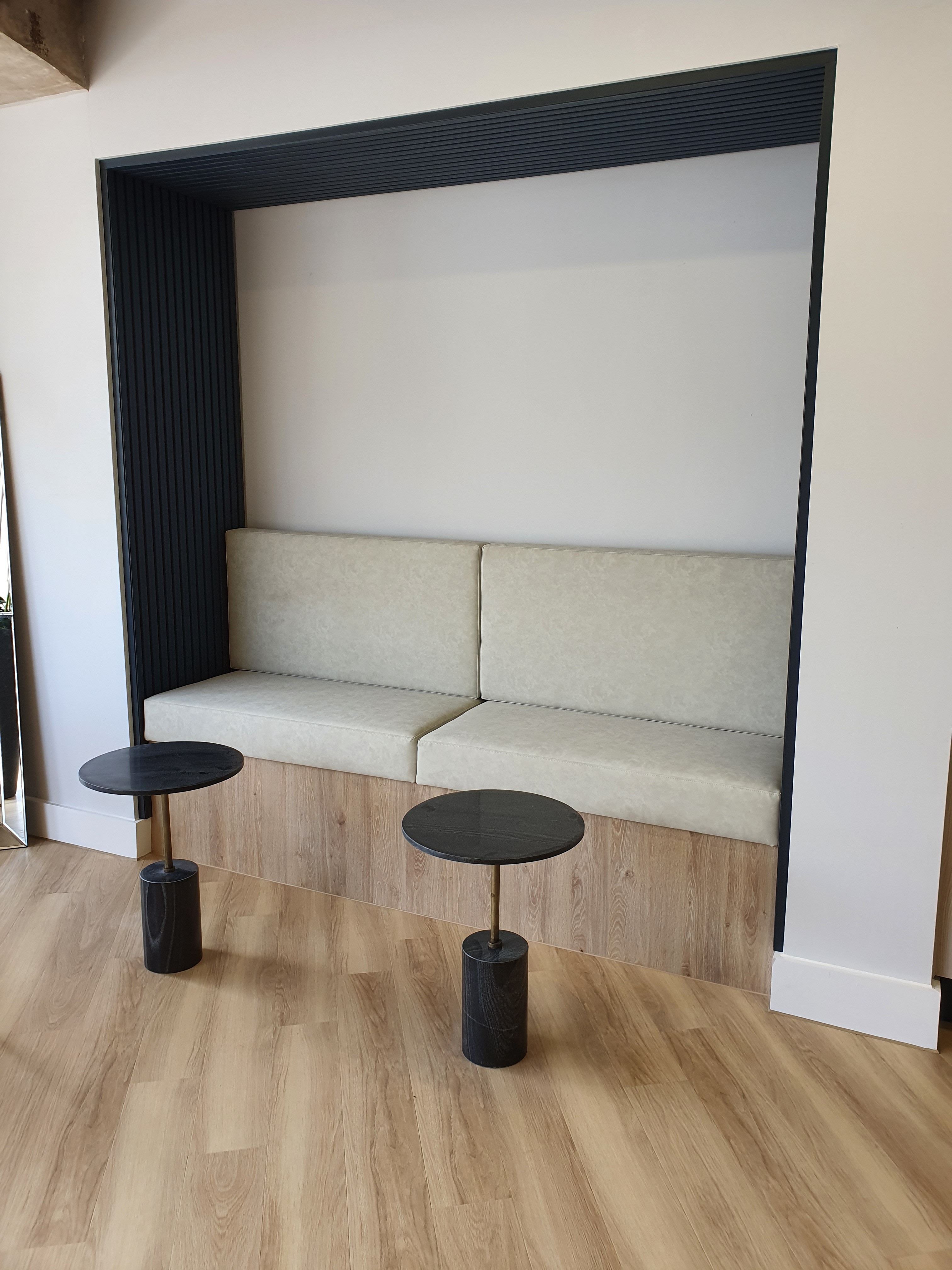 Bespoke joinery installation with upholstered seat pads and loose tables in Manchester office