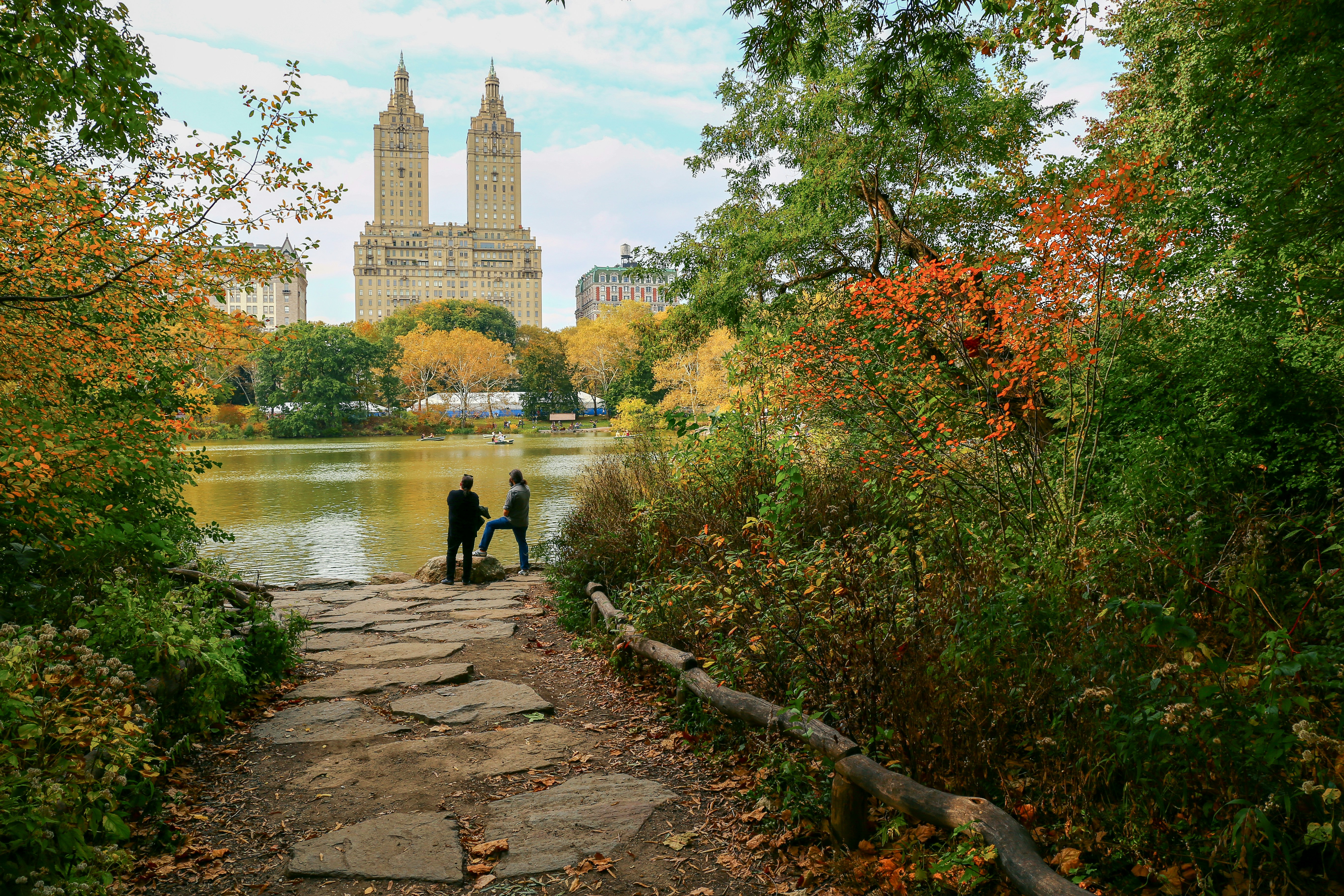 people walking on pathway near body of water during daytime