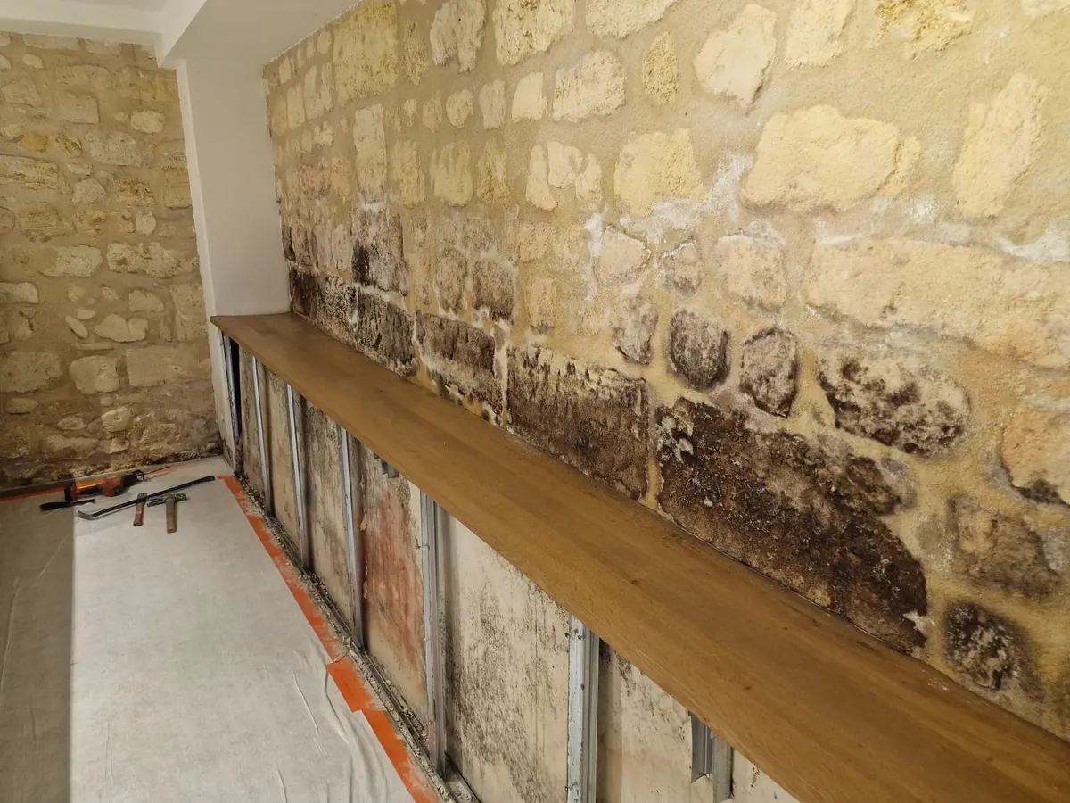 Mur en pierre présentant des traces d’humidité et de moisissures