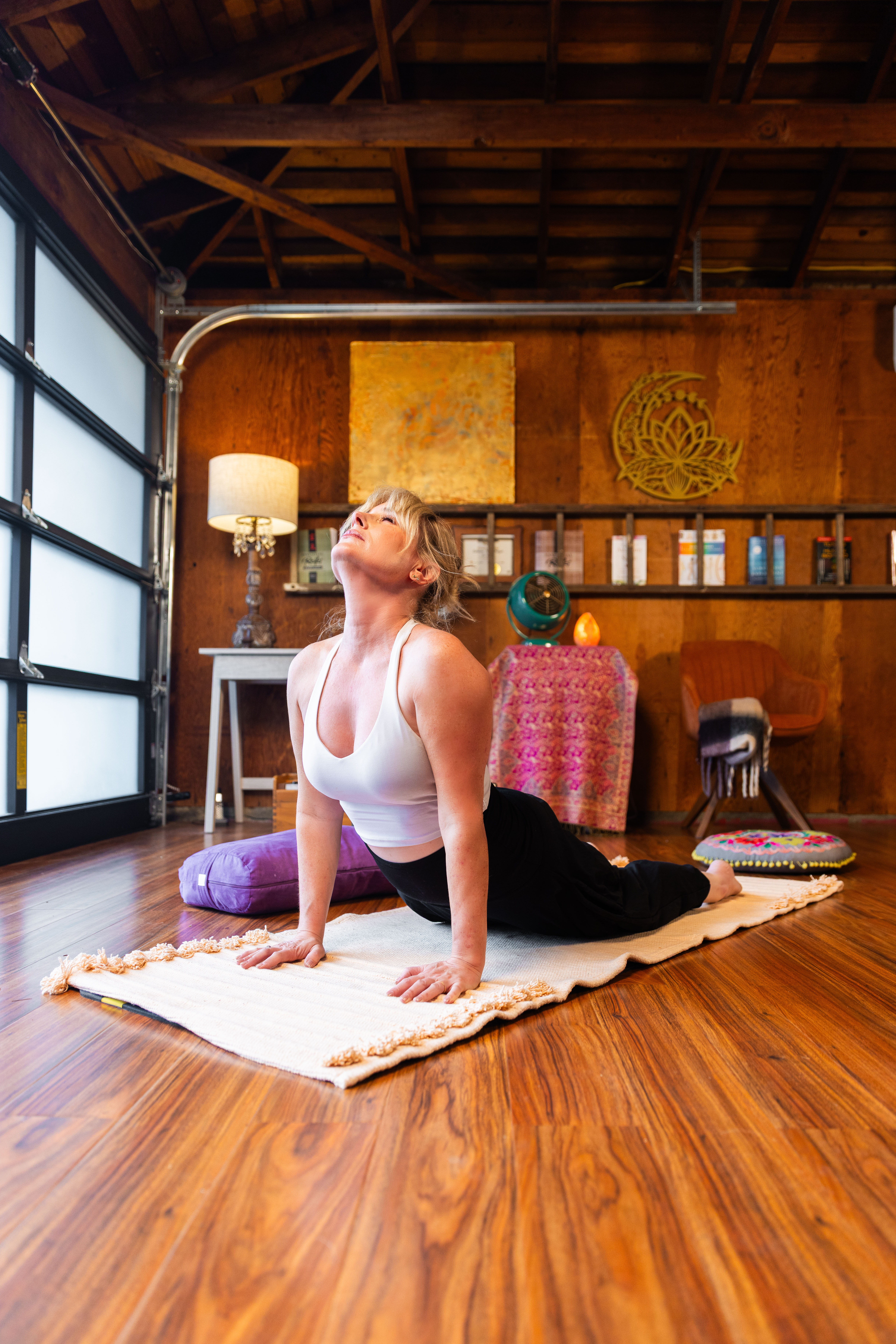 A young woman with wet hair, leaning back in a bath with her eyes closed. The sunlight reflects off the water, creating a serene and tranquil atmosphere.