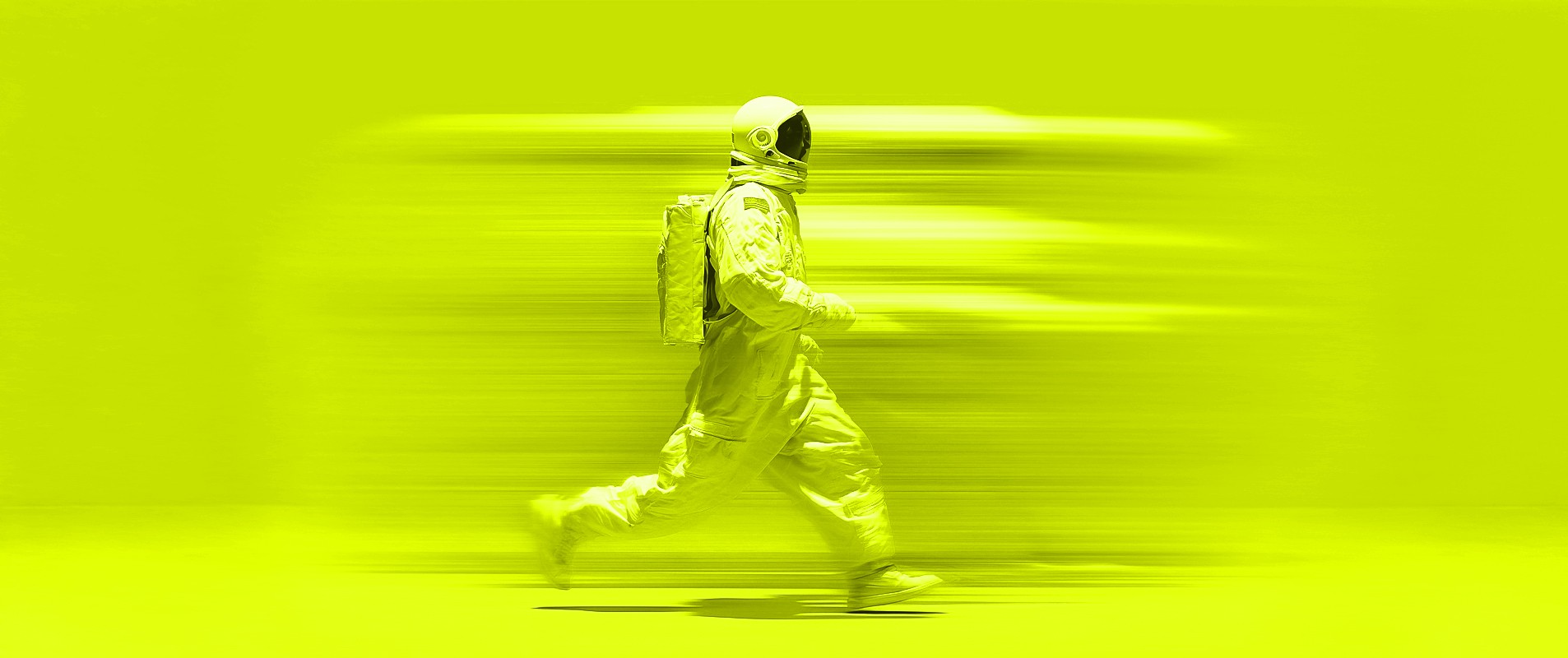 Astronaut in Bewegungsunschärfe vor einer stark leuchtenden Neon-Wand in Studiobelichtung.
