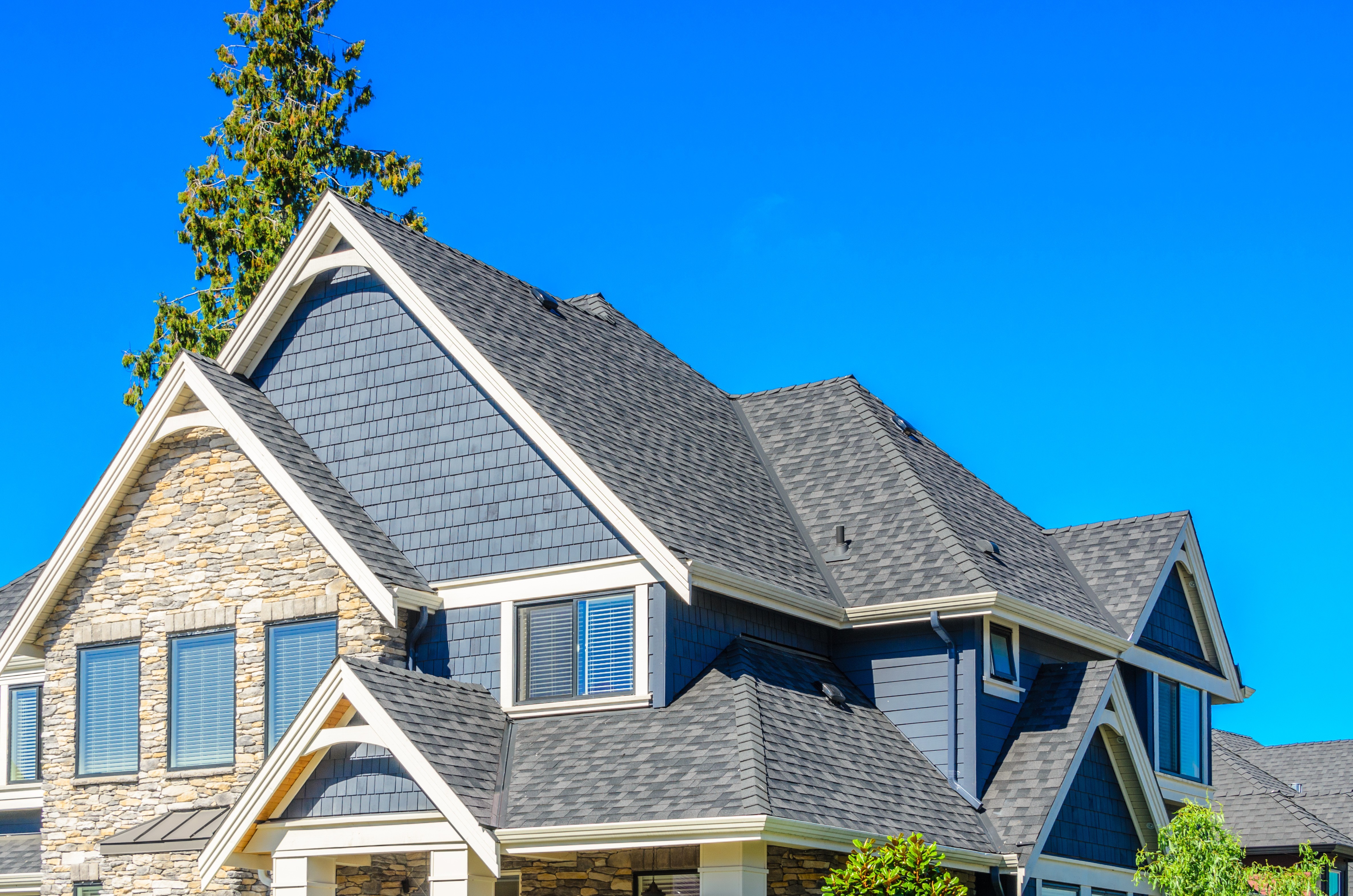 Residential roof repair in Chesterfield, MO with contractors replacing storm-damaged shingles on a suburban home.