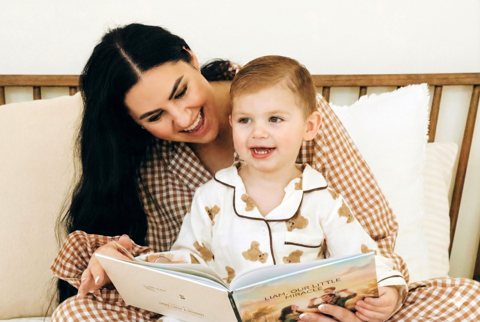 A winding road cuts through rocky terrain, surrounded by patches of green grass and illuminated by sunlight.